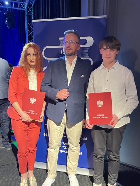 laureat z nauczycielką i kuratorem pozują do zdjęcia pamiątkowego 