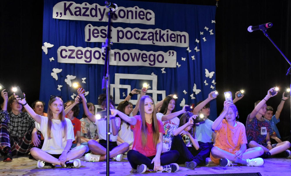 dzieci w kolorowych strojach występują na scenie domu kultury